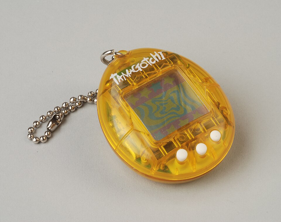 Tamagotchi galben din colecția Museum Rotterdam, numărul de inventar 78041, datat 1997 în fișa obiectului.