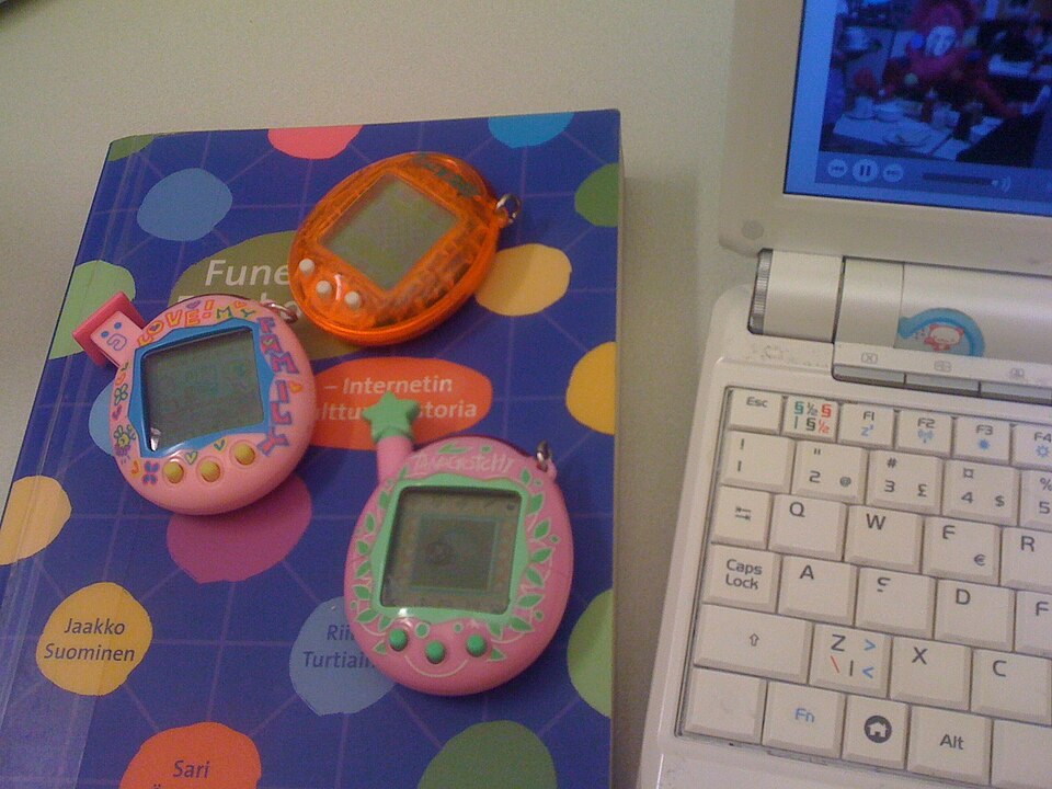 Trei dispozitive Tamagotchi cu carcase diferite, într-o fotografie realizată de xmacex în 2010.